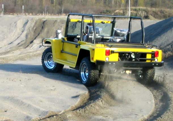 Rear View of Raised Cage Resort Wombat Driving in Sand